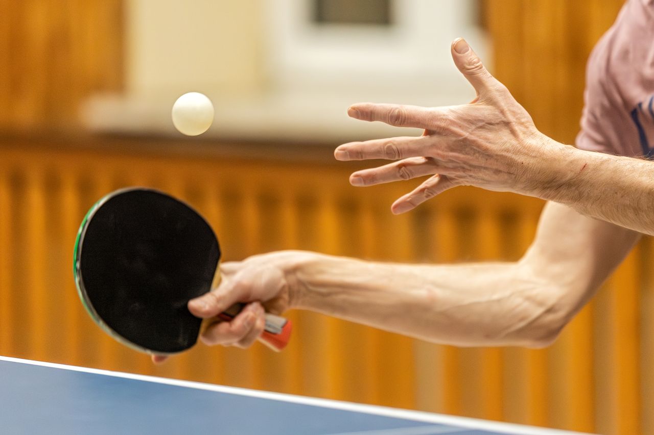 Mastering the First Impression: Your intriguing post title goes here Dynamic close-up of table tennis player serving, capturing the motion and focus of the game.